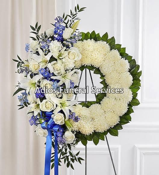 Circular funeral wreath of white chrysanthemums with yellow roses