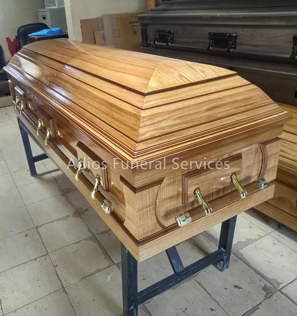 Polished golden-grain hardwood casket with gold handles