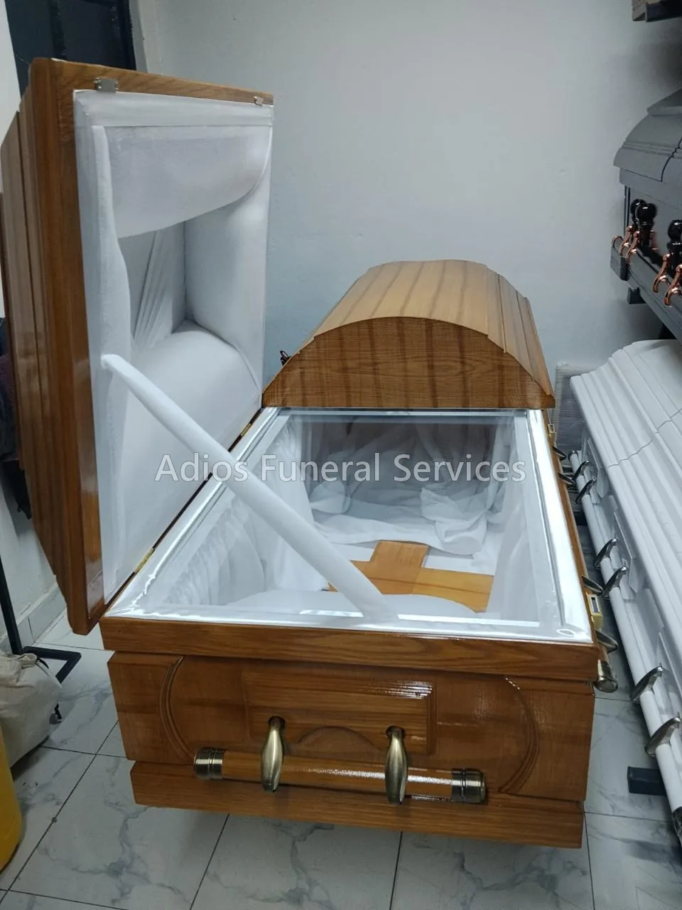 Split-lid casket open to show its white interior and viewing glass